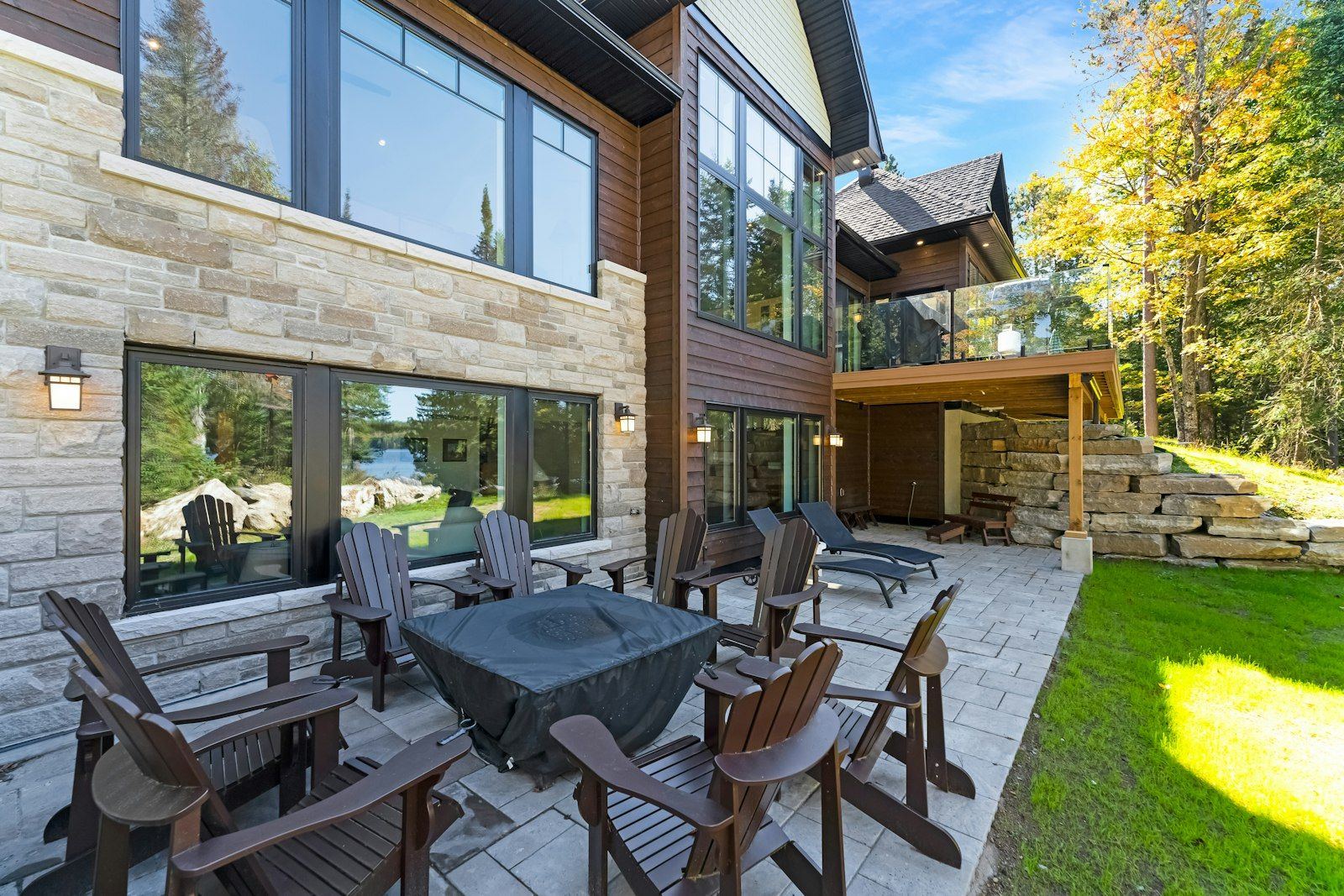 Stone patio with outdoor seating behind a modern house